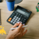 A table with a hand calculator and a CBN logo embedded